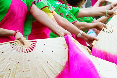 Women in traditional costume while dancing with folding fans at parade