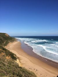 Scenic view of beach against blue sky