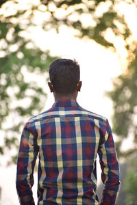 Rear view of man standing against trees