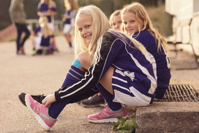 Portrait of happy girls tying shoelaces