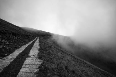 Road leading towards mountain against sky