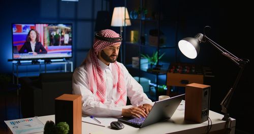 Portrait of man using laptop at office