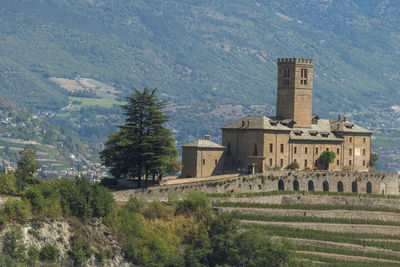 Trees and buildings against mountain range