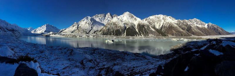 Scenic view of frozen lake against clear blue sky