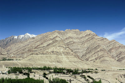 Scenic view of mountain range against blue sky