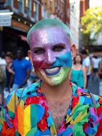 Portrait of smiling man with multi colored umbrella