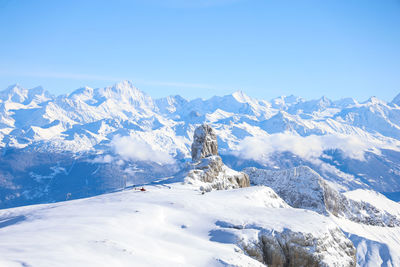 Scenic view of snowcapped mountains against clear blue sky