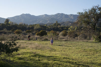 Scenic view of girls running on landscape