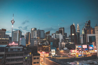 Illuminated buildings in city against sky