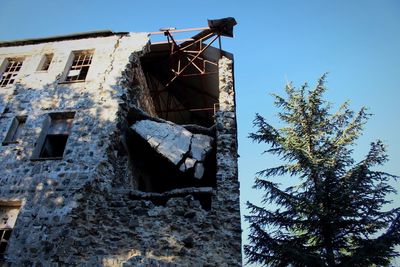 Low angle view of abandoned building against sky