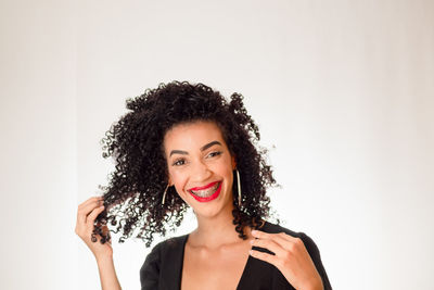 Portrait of young beautiful smiling woman with hand in hair. looking at the camera. 