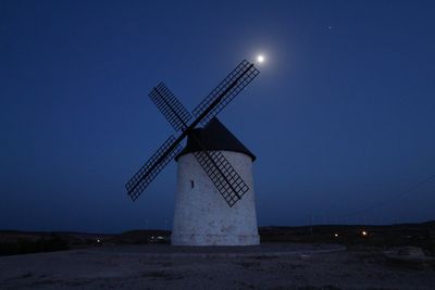 Traditional windmill against clear sky at night