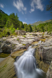 Scenic view of waterfall against sky