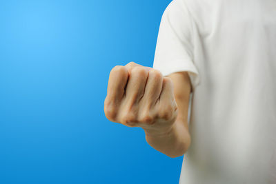 Close-up of man hand against blue background