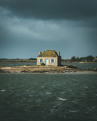 House amidst sea against sky