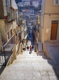 People walking on stairs along built structures