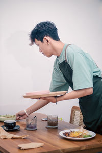 Side view of young man working at table