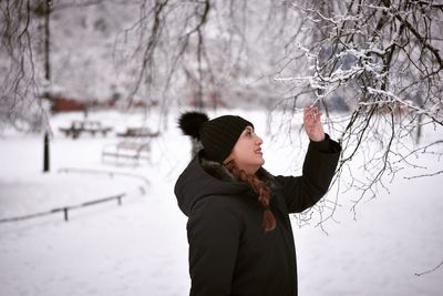 Man standing on snow covered tree