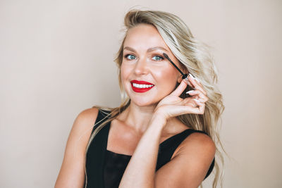 Portrait of young woman with eyes closed standing against wall