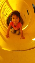Cute girl playing in tunnel at playground