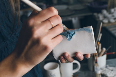 Close-up of woman painting pottery