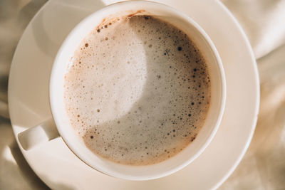 Dirty white cup of tea with milk foam. morning coffee. latte cappuccino. breakfast. cafe