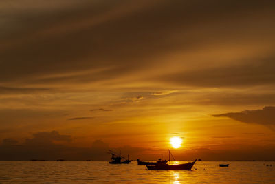 Silhouette boats in sea against sky during sunset