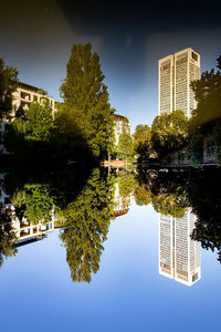 Reflection of trees and buildings in lake