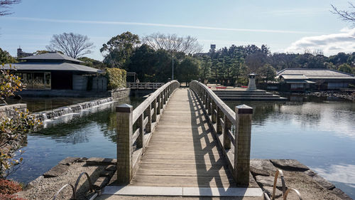 Footbridge over river against sky