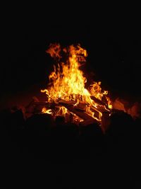 Close-up of bonfire on field against sky at night