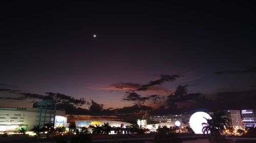 Crowd at illuminated city against sky at night