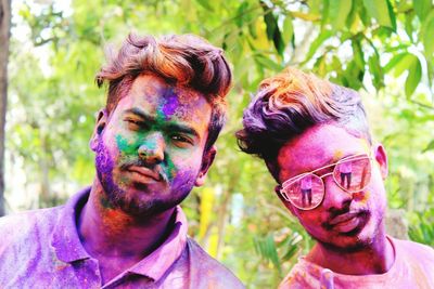 Close-up portrait of friends with powder paint on face