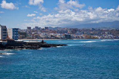 Scenic view of sea and buildings against sky