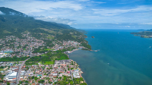 High angle view of townscape by sea against sky