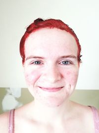 Portrait of smiling young woman against white background