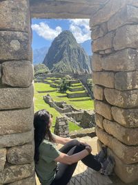 Rear view of woman sitting on rock