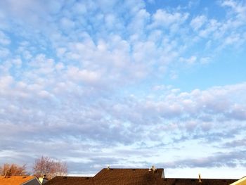 Low angle view of buildings against cloudy sky