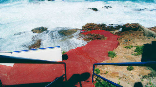 High angle view of red steps leading to sea