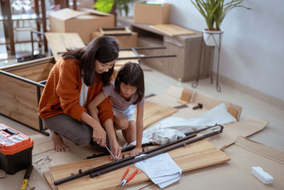 Mother and daughter assembling furniture