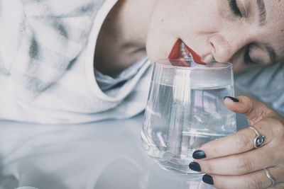 Close-up of man drinking glass with water