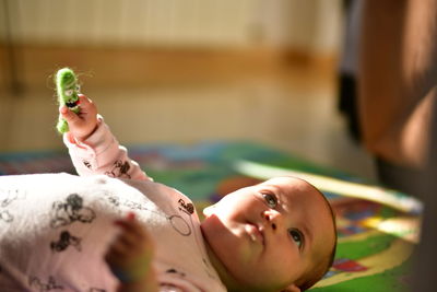 Cute baby girl lying on bed at home