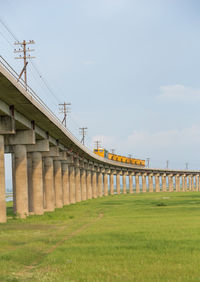 Low angle view of bridge on field against sky