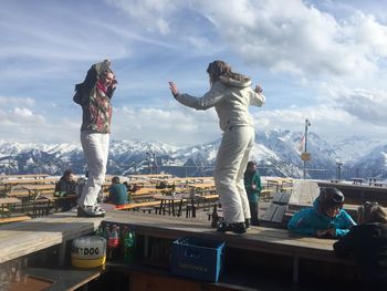 People standing on mountain against sky