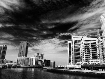 Buildings in city against cloudy sky