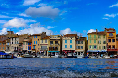Buildings in city against cloudy sky