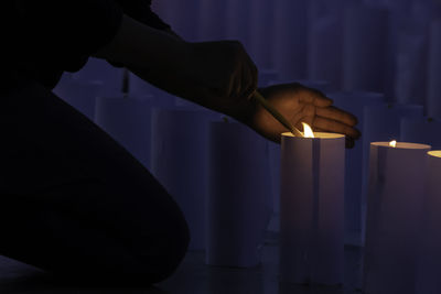 Midsection of person holding illuminated candles