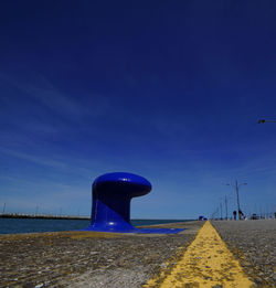View of empty road against blue sky
