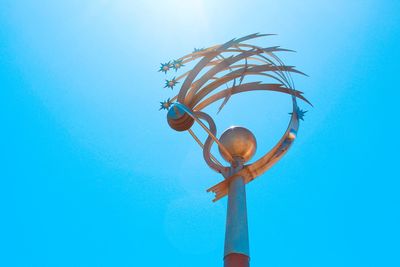 Low angle view of electric lamp against clear blue sky