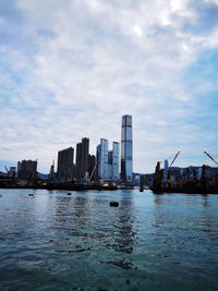 Sea by buildings against sky in city