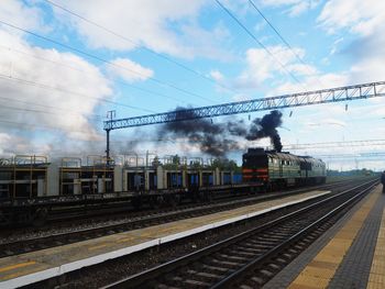 Train at railroad station against sky